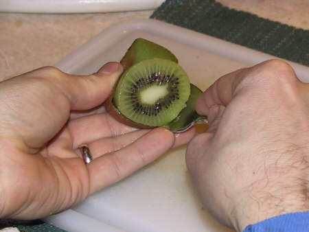 using a spoon to peel a kiwi